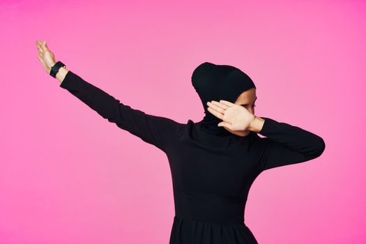 muslim woman in black hijab posing hand gesture model. High quality photo