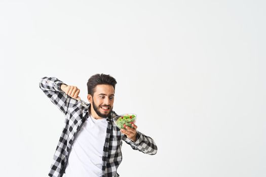 man in plaid shirt eating salad healthy food. High quality photo