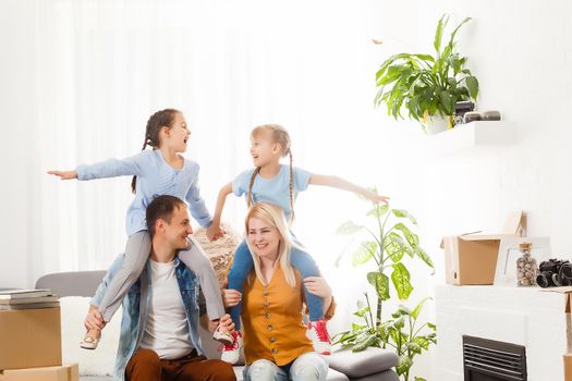 Happy family with cardboard boxes in new house at moving day.