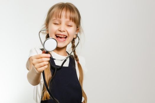 Smiling little girl playing doctor with stethoscope isolated on white