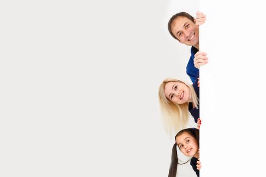 Banner with family. Happy father, mother, daughter looking on camera and holding big white blank board in hands