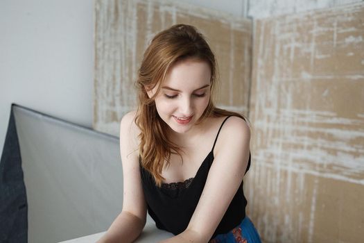 Beautiful young woman in black top, blue skirt, indoors portrait of cute attractive model. caucasian skinny female with long brown hair on abstract background. natural pretty lady posing at studio