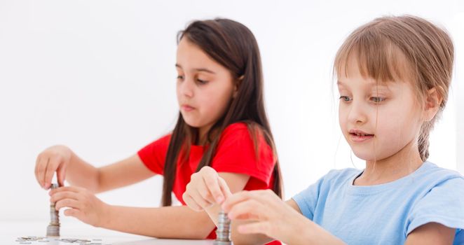 Two kids counting coins together