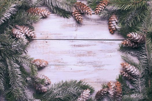 White shabby Christmas border with snow covered pinecones