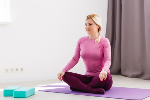 Beautiful young woman doing yoga at home.