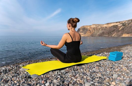 Group of young womans fitness instructor in Sportswear Leggings and Tops, stretching in the gym before pilates, on a yoga mat near the large window on a sunny day, female fitness yoga routine concept.