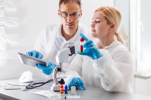 Flu virus experiment - scientist in laboratory with microscope, wear protective eyewear