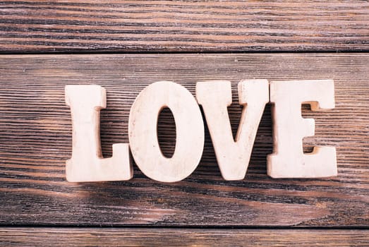 Wooden letters LOVE on a wooden background