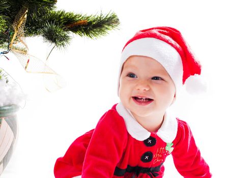 Santa baby girl in dress near Christmas tree with mother's hand - my first holiday