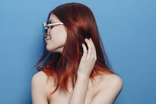 attractive woman with bare shoulders fashionable glasses blue background. High quality photo