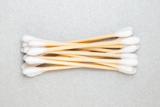 Heap of bamboo cotton ear swabs on grey background. Zero Waste alternative to plastic sticks