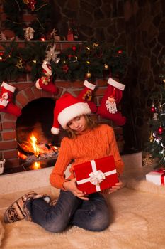 Teenage girl in christmas decorated room open a giftbox