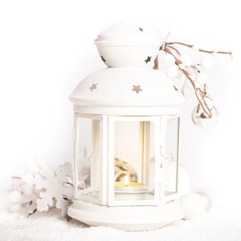 Cristmas lantern with decorations and snow over white background