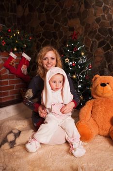 Mother with son in a rabbit costume. New year holiday decorations