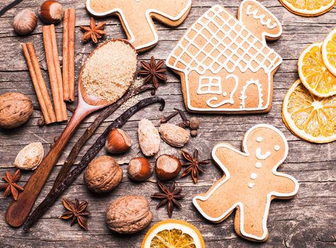 Gingerbread cookies on a wooden table with ingredients