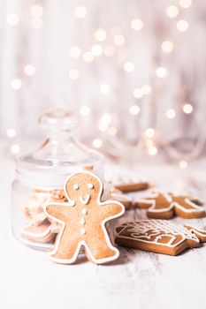 Gingerbread cookies on a table and Christmas lights on background