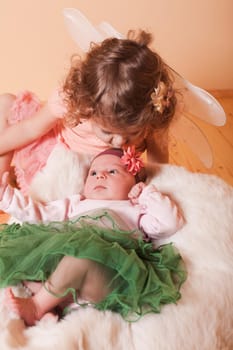 Little girl with her newborn sister in a basket