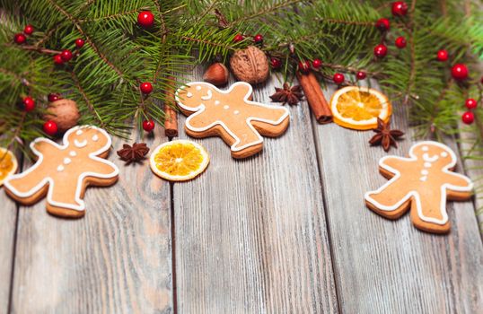 Gingerbreads and fir tree branches on the wooden table. Christmas decor