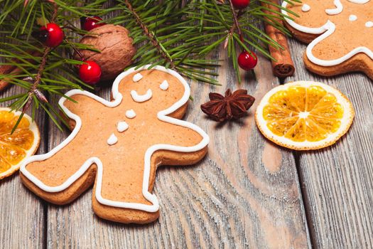 Gingerbreads and fir tree branches on the wooden table. Christmas decor