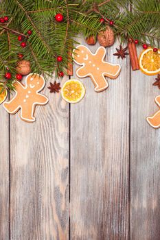 Gingerbreads and fir tree branches on the wooden table. Christmas decor