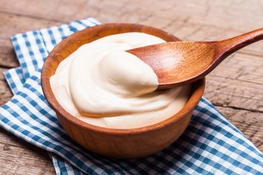 Sour cream in a wooden bowl. Farm organic product