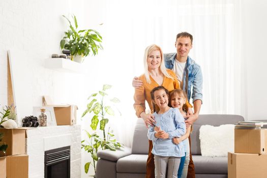 Happy family with cardboard boxes in new house at moving day.