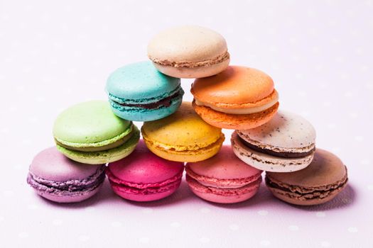 Colorful macaroons - french dessert over pink polka dot napkin