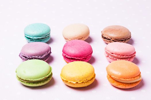 Colorful macaroons - french dessert over pink polka dot napkin