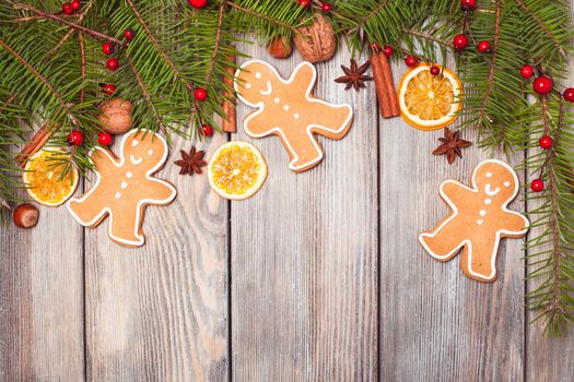 Gingerbreads and fir tree branches on the wooden table. Christmas decor