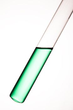 Laboratory glass tube with green liquid on white