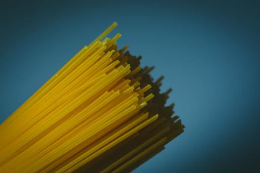 Durum wheat spaghetti on a dark blue background. Raw pasta.