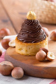 Tart with chocolate cream and golden nut on top close up