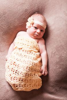 Newborn baby girl on the crochet blanket