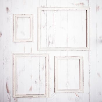 Shabby chic white frames on wooden wall