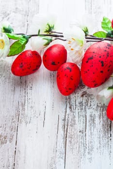 Red spotted eggs with apple flowers on the shabby wooden table