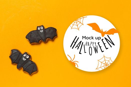 Halloween concept - black cookies bats on orange background