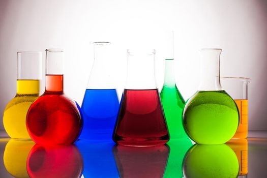 Laboratory glass with rainbow color liquids, chemistry still life