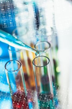 The blue drop from pipette over laboratory tubes and periodic table background