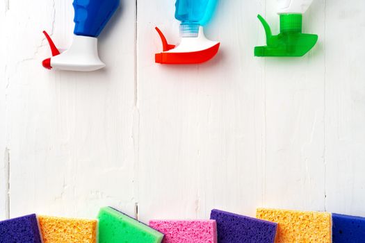 Home cleaning supplies on white wooden background, top view photo