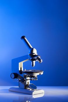 Microscope on the table in laboratory with blue light