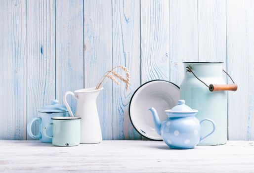 Enamelware on the kitchen table over blue wooden wall