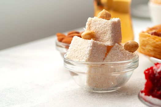 Various Turkish sweets on white textured background, close up