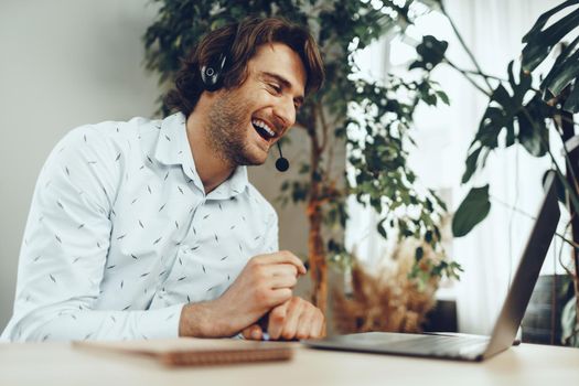 Young caucasian businessman holding video call with clients partners by laptop