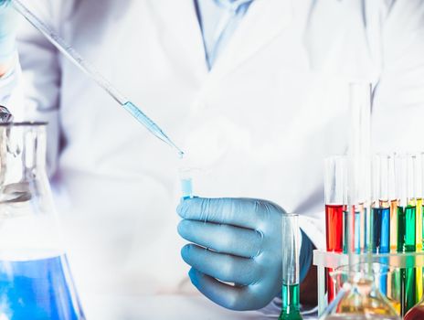 Scientist holds eppendorf tube and pipette. Focus on test tube