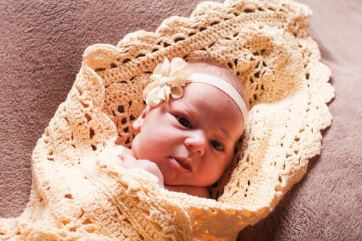 Newborn baby girl on the crochet blanket