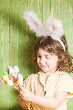 Girl with bunny ears and little eggs. Easter celebration