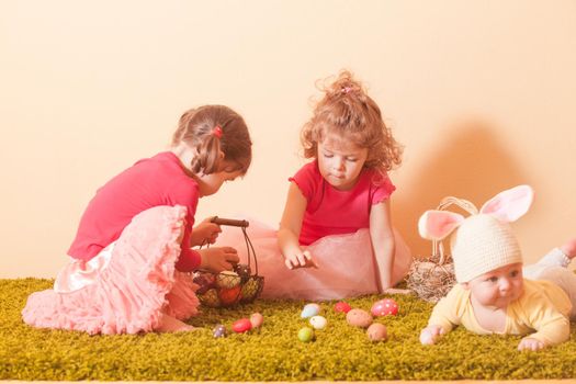 Kids gather colorful eggs to the baskets on Easter Egg hunt
