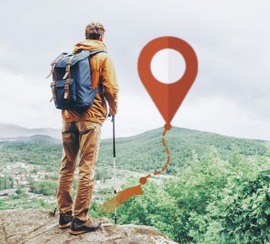 Hiker backpacker young man with trekking poles standing on edge of cliff outdoor and scheme of track with connected location pin. Navigation concept.
