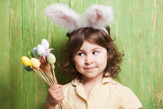 Girl with bunny ears and little eggs. Easter celebration