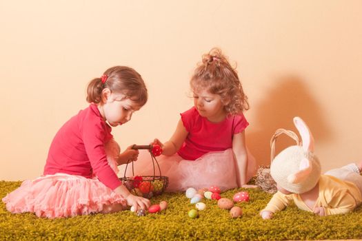 Kids gather colorful eggs to the baskets on Easter Egg hunt